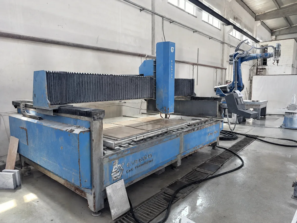 Bridge-type 5-axis CNC machine with the robot cell behind it